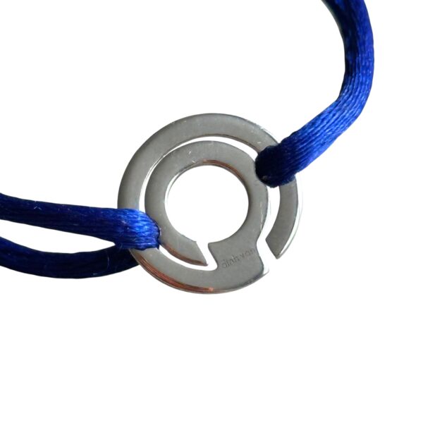 Détail du motif circulaire du bracelet Dinh Van Seventies en or 18 carats, avec gravure dinh van et cordon bleu.